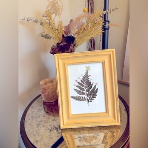 An adorable pressed flower artwork, composed of a real fern plant and roses.